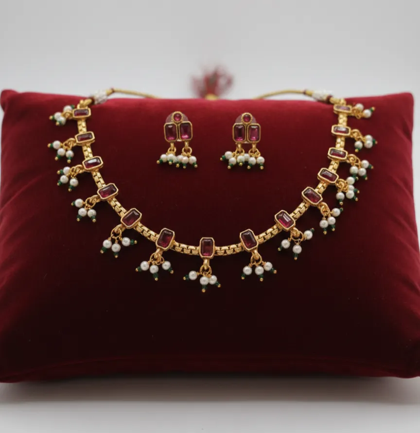 The timeless charm of this ruby-stoned necklace set, featuring elegant geometric stones and delicate pearl clusters.