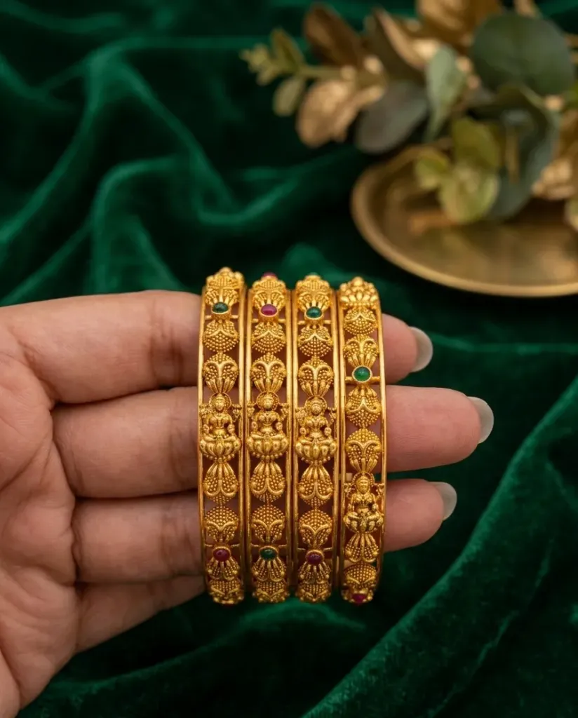 Antique style gold-toned bangles with detailed temple motifs and emerald & ruby gems. (2.4)