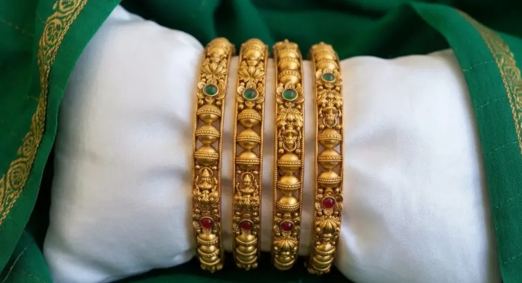 Ornate Bangle Set with detailed temple motifs and alternating green & red stone accents, perfect for traditional wear. (2.4)