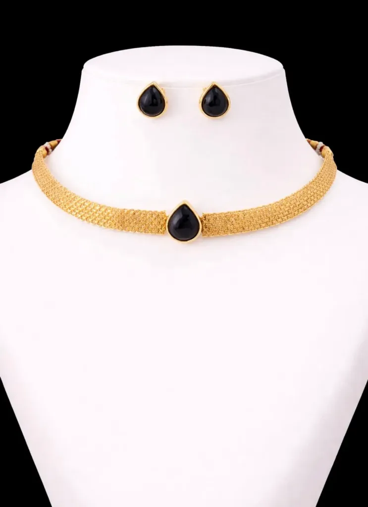 A stunning choker necklace with a pear-shaped black gemstones at its center,paired with matching teardrop black gemstone earrings in golden settings.