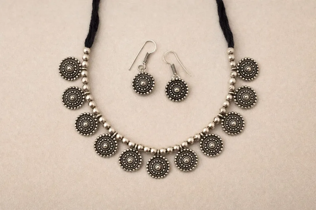 Statement oxidized necklace set with detailed coin design  and elegant Dori finish.