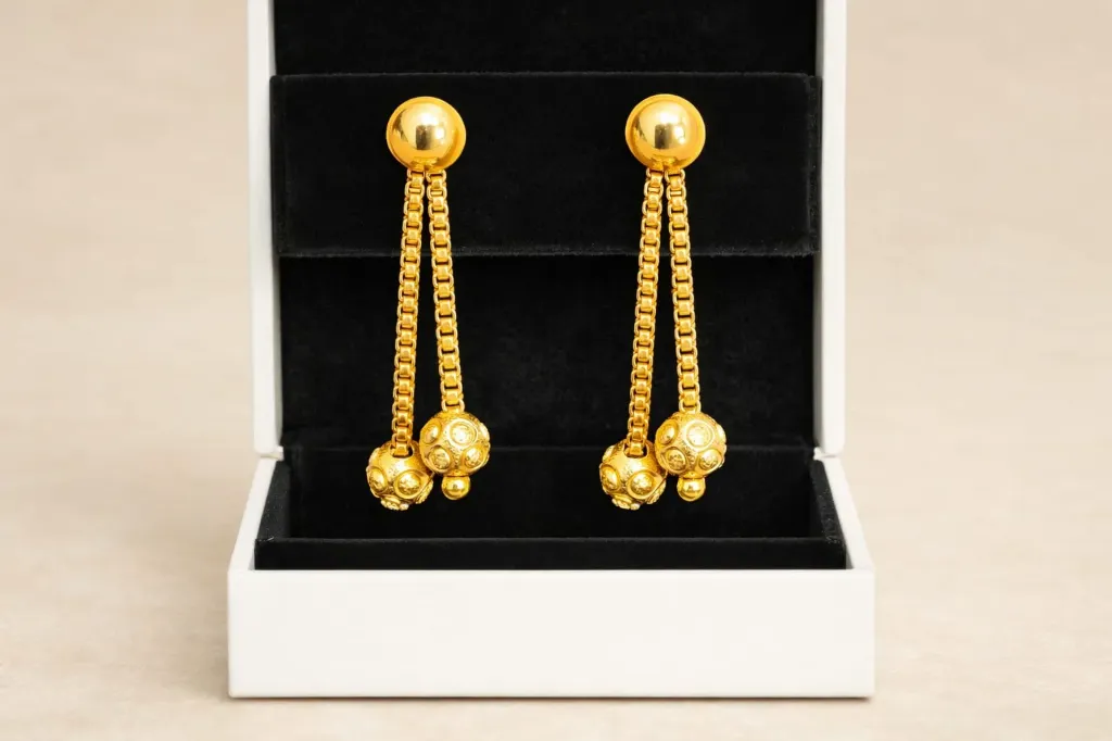 Elegant drop-chain earrings-turn heads with shimmering gold spheres.
