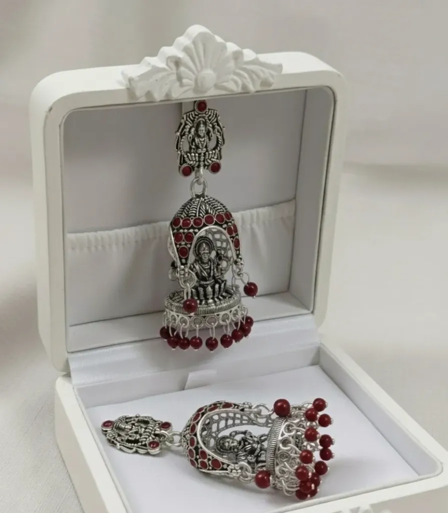 Embrace a classic ethnic look with these oxidized Jhumkas, showcasing intricate Temple art and vibrant Maroon bead detailing.