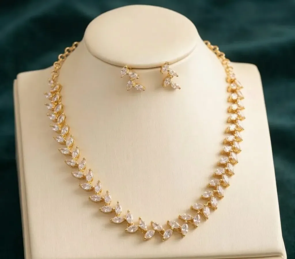 Radiate elegance with this exquisite gold-toned necklace set, featuring a delicate vine of marquise-cut American Diamonds that capture light with every movement.