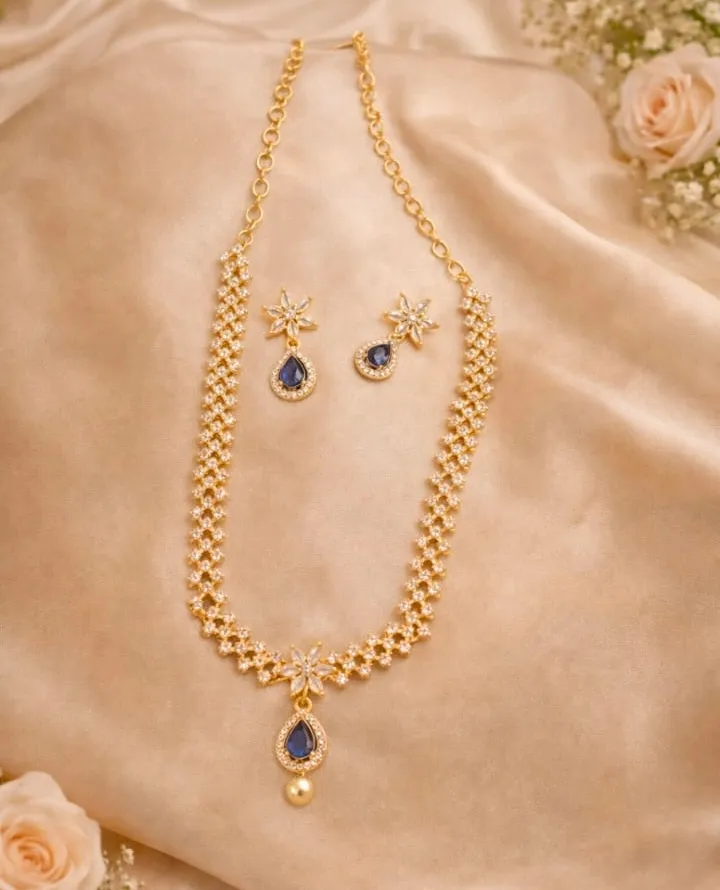 Add a touch of timeless elegance to your collection with exquisite gold toned AD neckless set, featuring delicate floral motifs and blue teardrop accents.