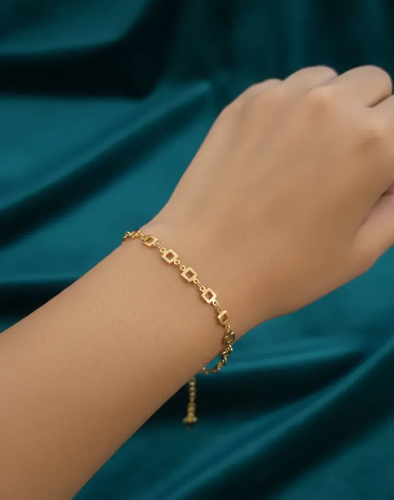 Elegant and versatile, this gold-toned bracelet features a delicate chain of geometric square links that add a modern touch to any outfit.