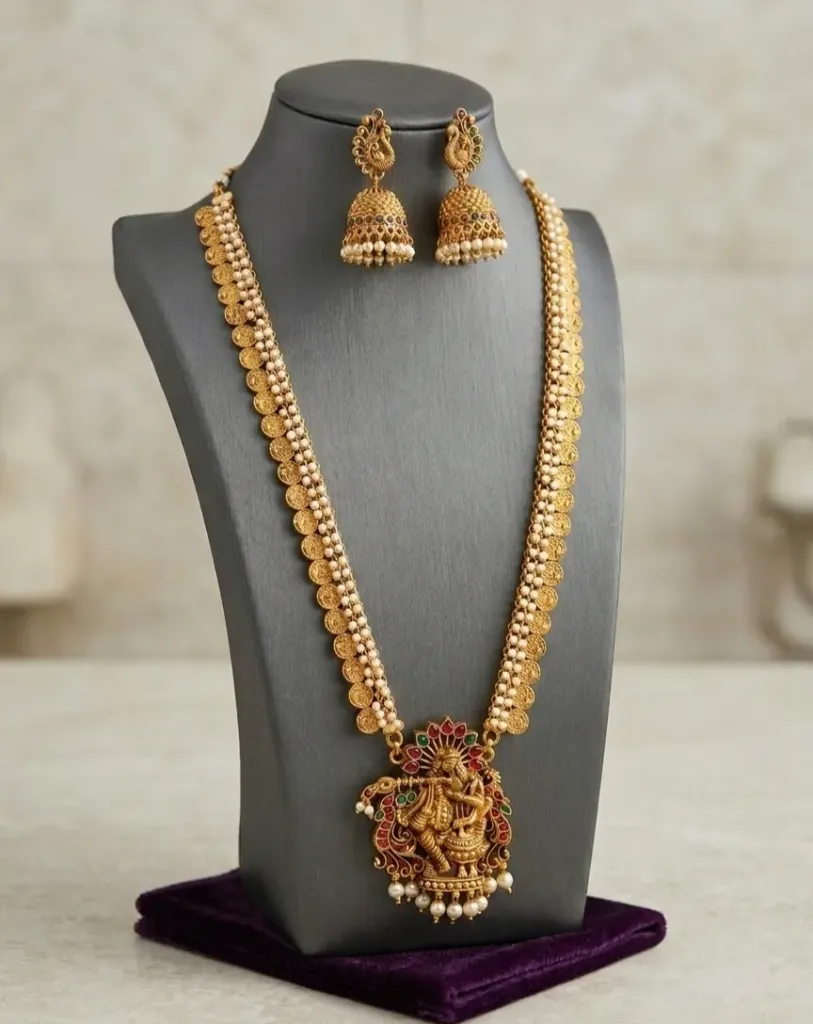 Traditional coin-style gold-toned necklace featuring Lord Krishna motif and pearl-details jhumkas.