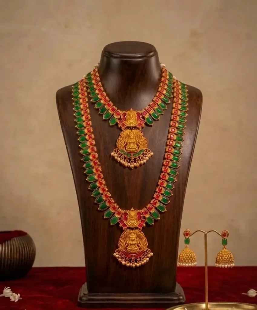 Adorned with the hues of tradition, these gold treasure echo the artistry of generation-red and green gemstones dancing in harmony, regal symphony of heritage and devotion.