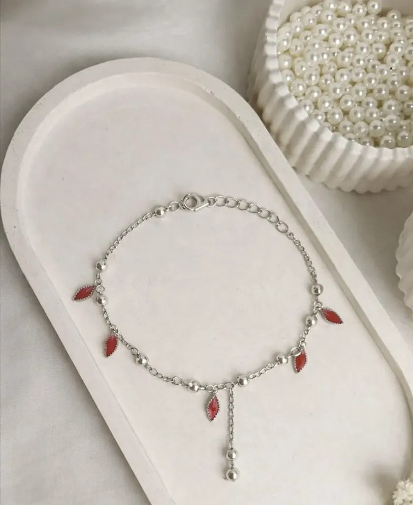 A Stunning silver bracelet adorned with red marquise-shaped charms and tiny silver beads.