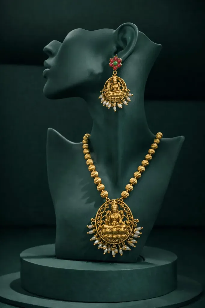 Elegant gold toned jewellery set featuring Lakshmi pendent necklace & matching earrings.